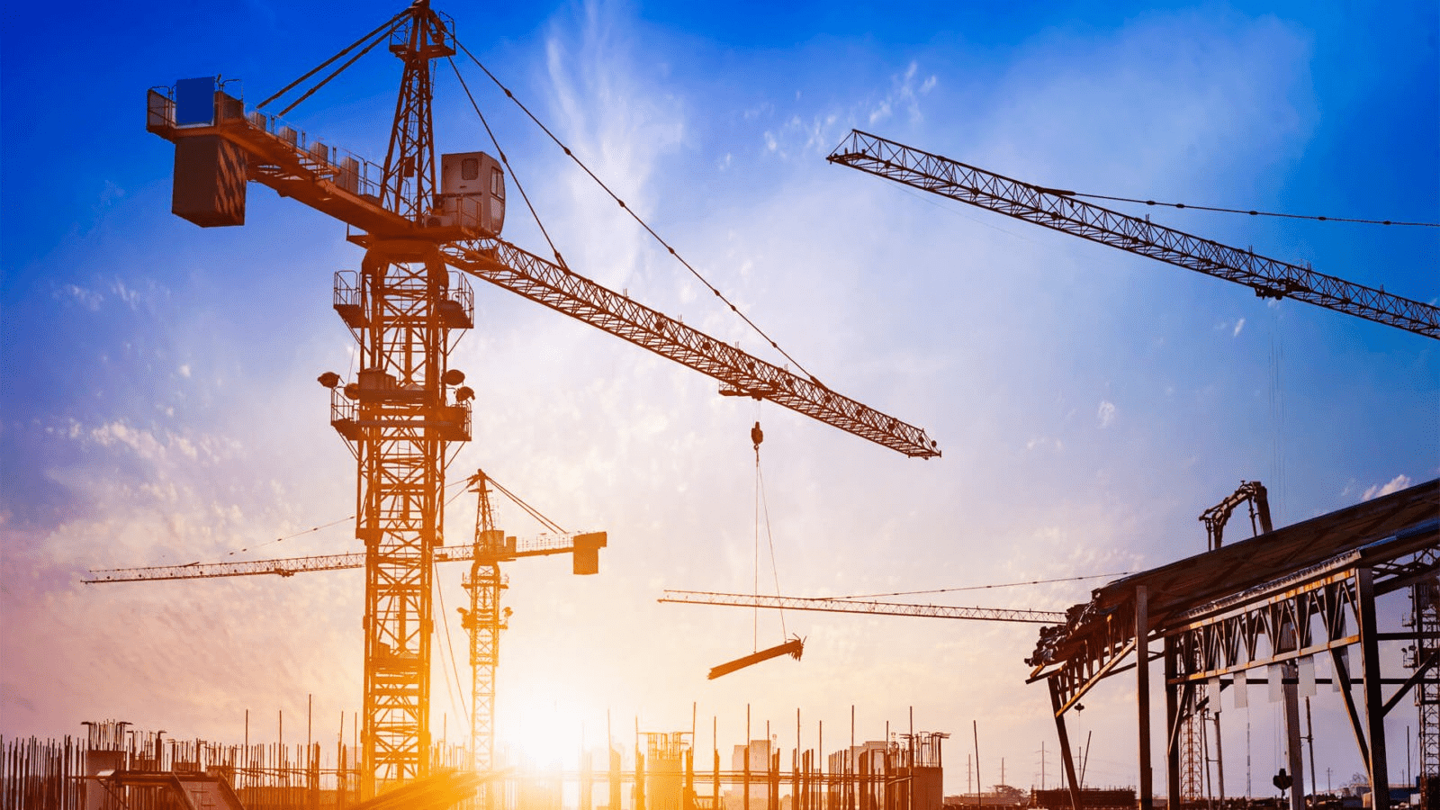 Tower cranes in a construction building at sunrise